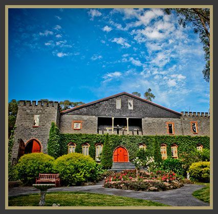 A large stone building with a red door and a bench in front of it