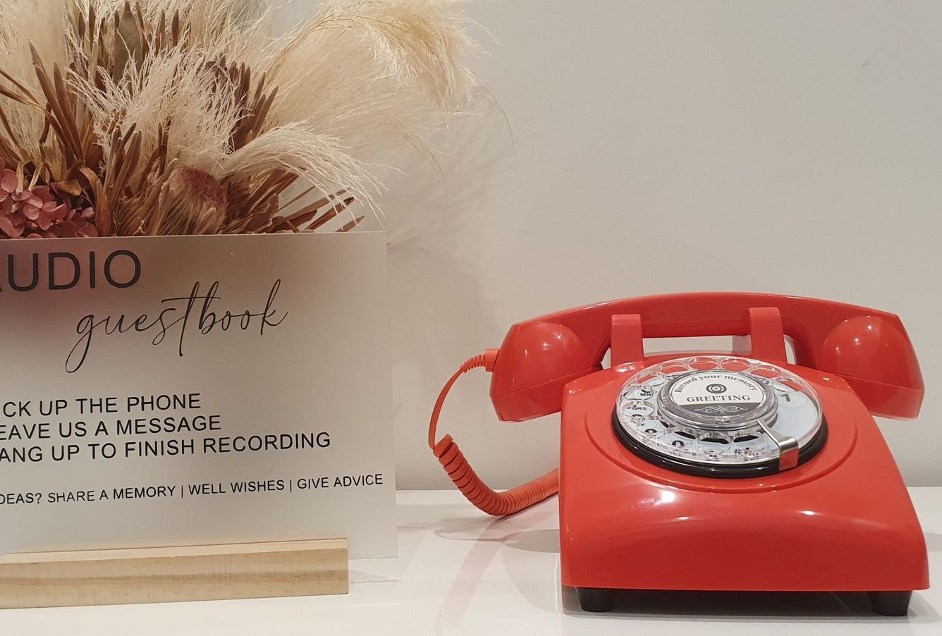 A red telephone is sitting next to a sign that says studio guesthouse