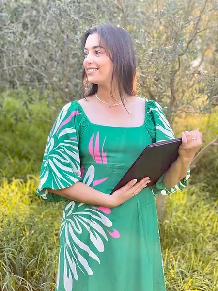 A woman in a green dress is holding a clipboard.
