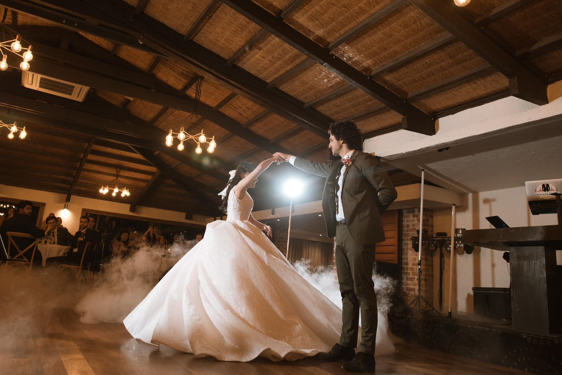A bride and groom are dancing their first dance at their wedding reception.
