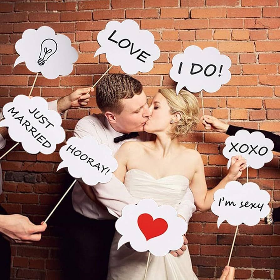 A bride and groom kissing in front of a brick wall