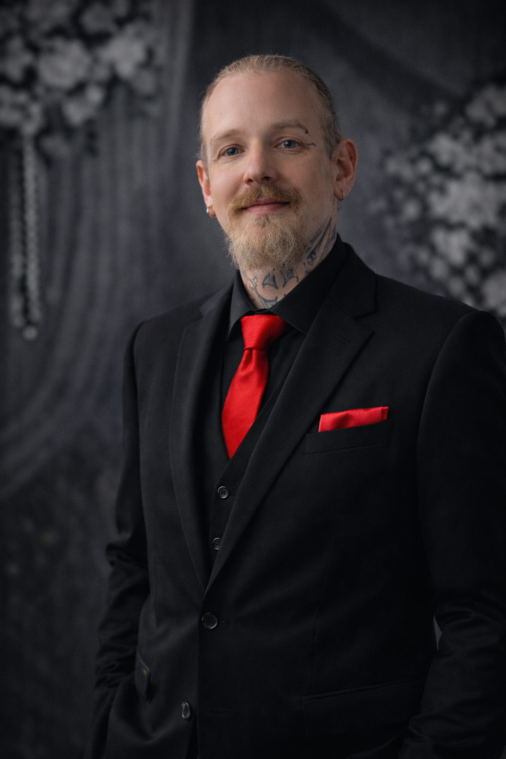 A man with a beard is wearing a suit and tie