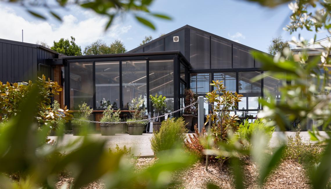 A large building with a lot of windows is surrounded by trees.