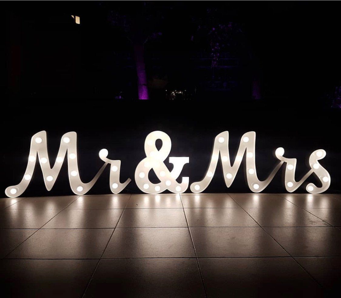 A mr and mrs sign is lit up in the dark
