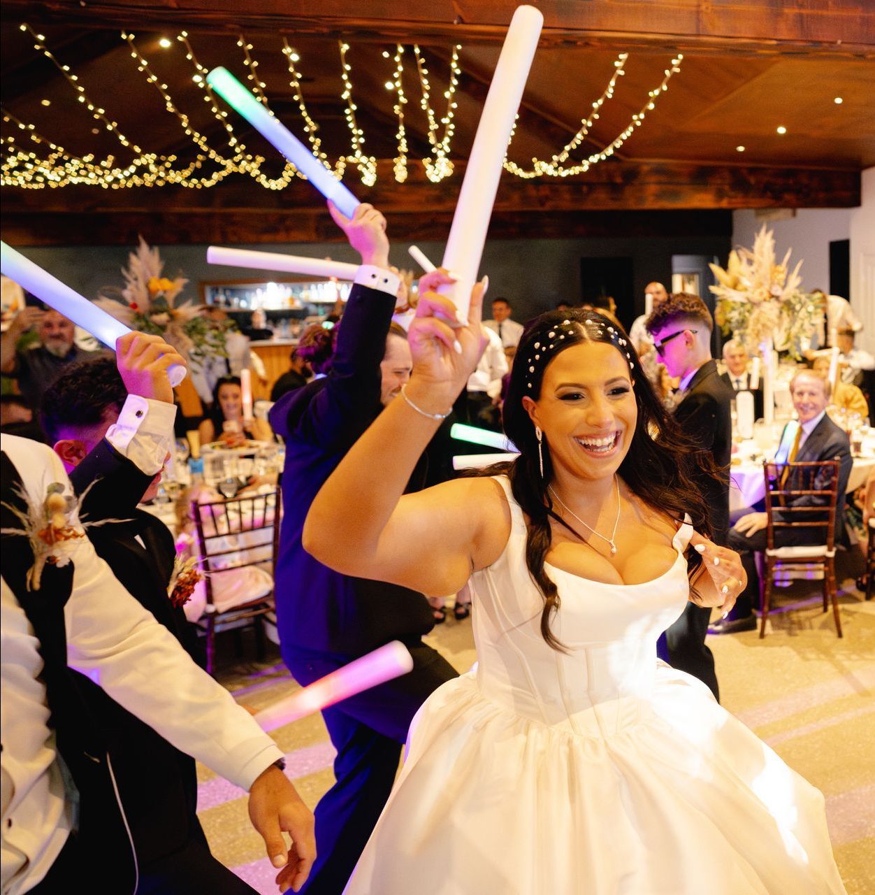A woman in a wedding dress is playing music on a laptop.