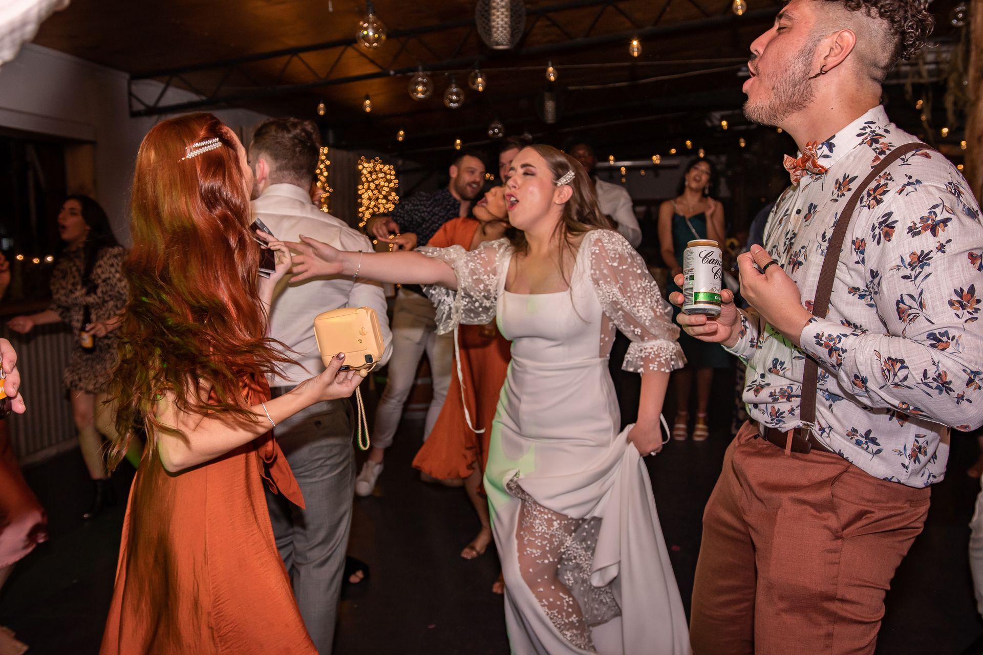 A group of people are dancing at a wedding reception.