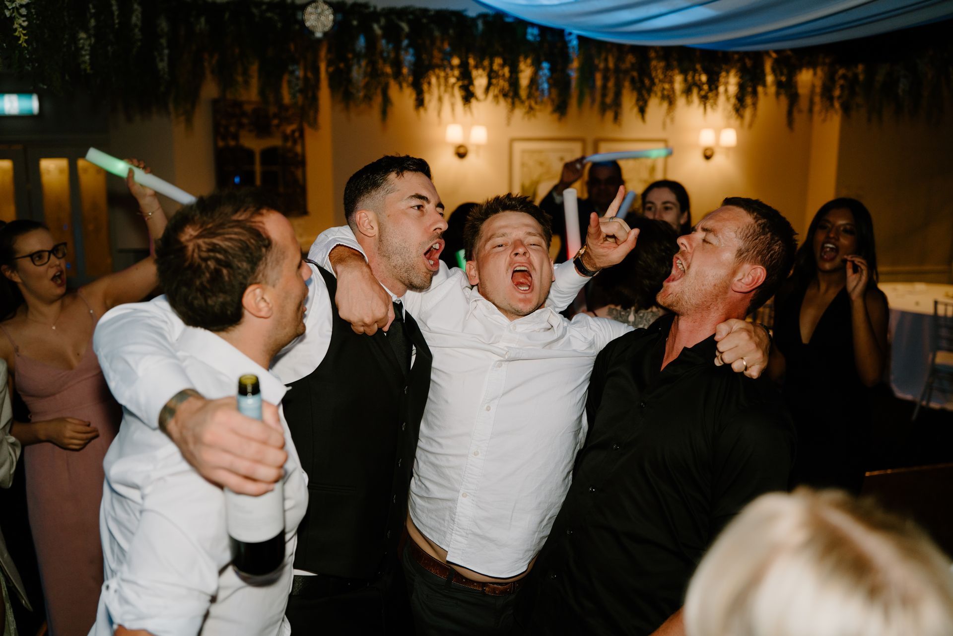 A group of people are dancing together at a wedding reception.