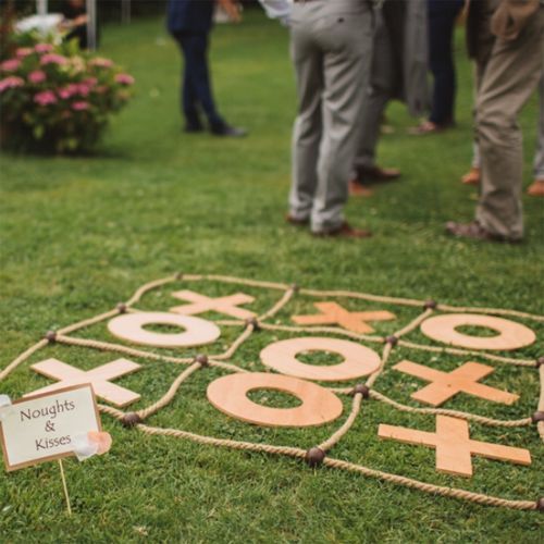 A group of people standing around a giant tic tac toe game