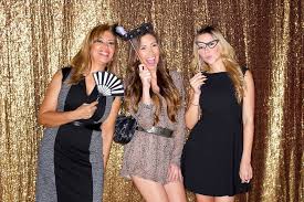 Three women are posing for a picture in a photo booth.
