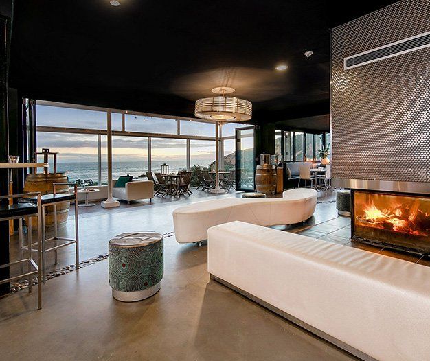 A living room with a fireplace and a view of the ocean