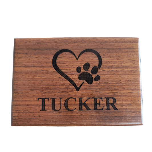A wooden box with a heart and paw print and the name tucker on it.