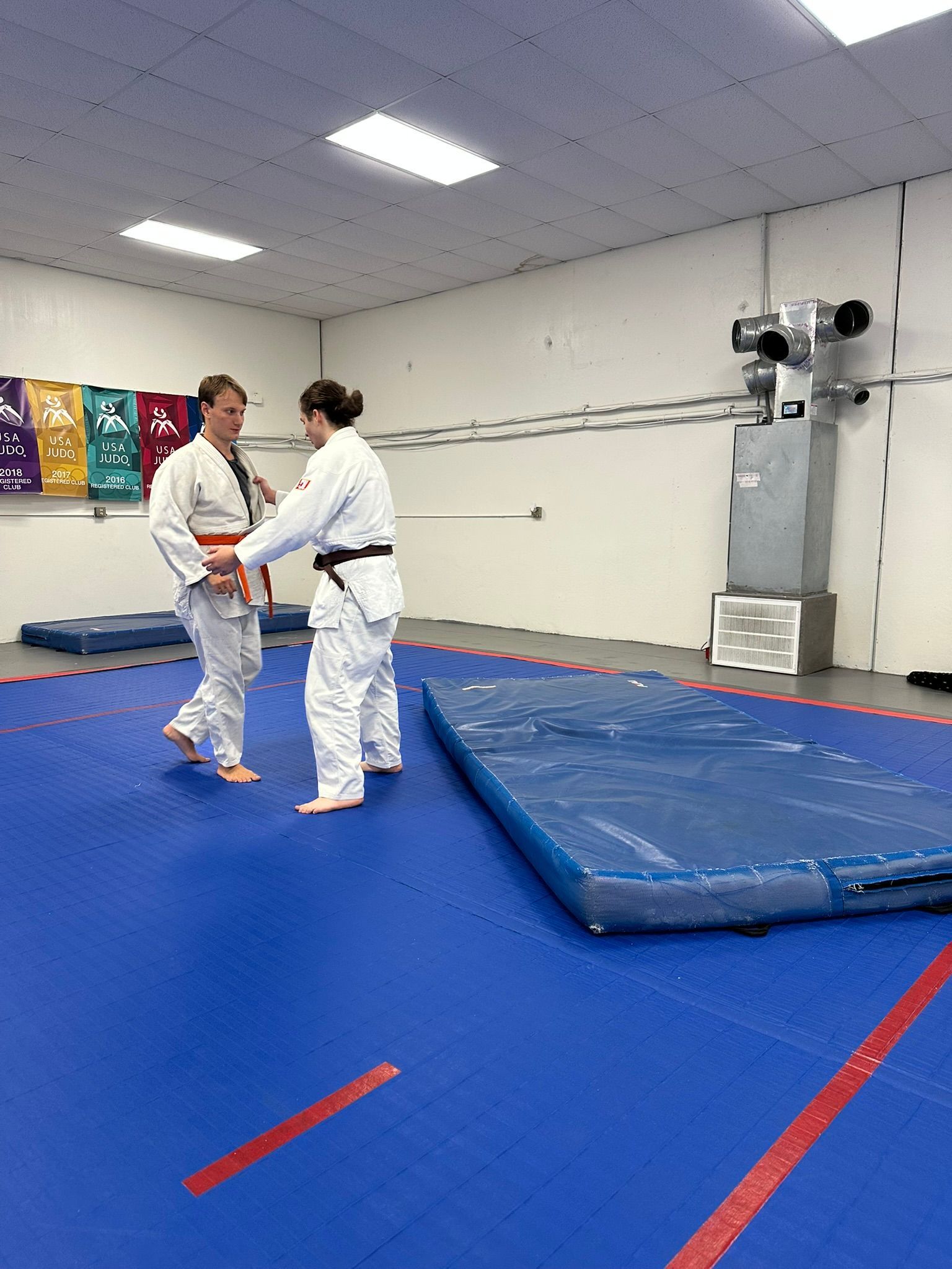 Kids and adults practice safe Judo breakfalls at Champion Martial Arts & Fitness in Pasadena, TX.