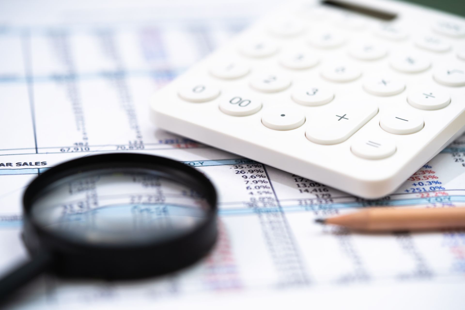 Person in suit calculating taxes on a calculator and laptop.