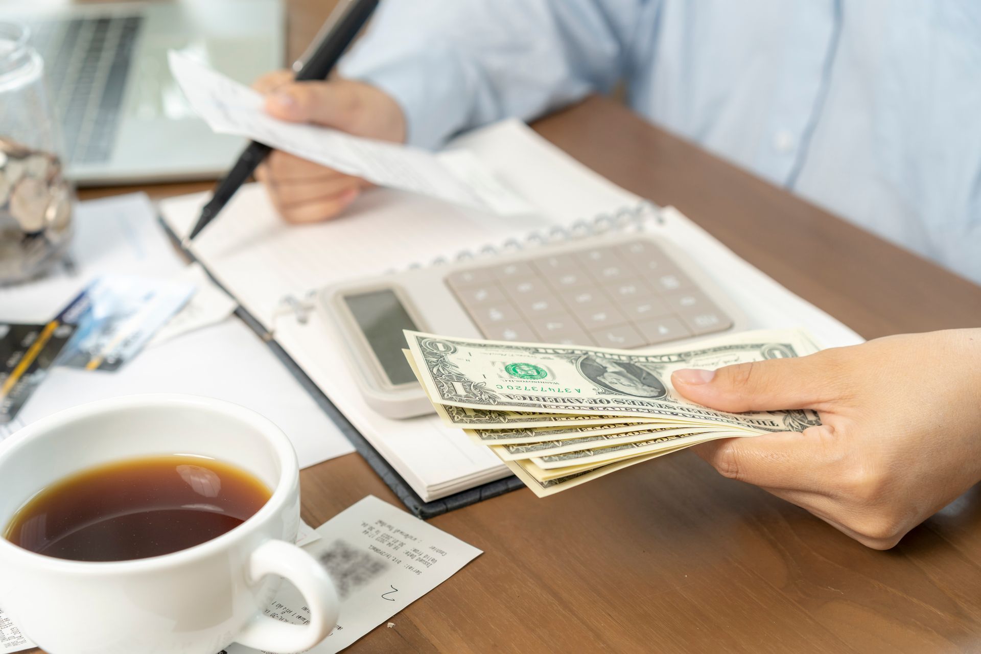 Close-up of blue-tinted employment and payroll documents with financial data and tables.