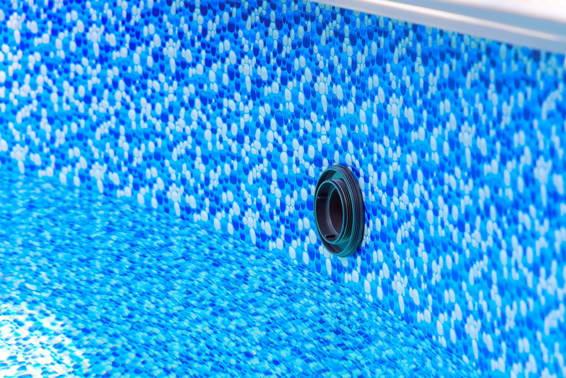 Close-up of a mosaic blue liner with a drainage pipe. Close-up of a mosaic blue liner with a drainage pipe.