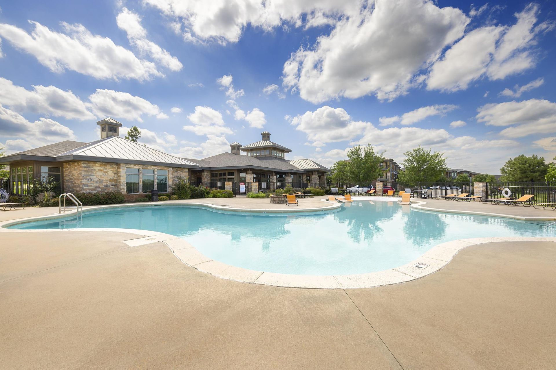 A large swimming pool with a house in the background