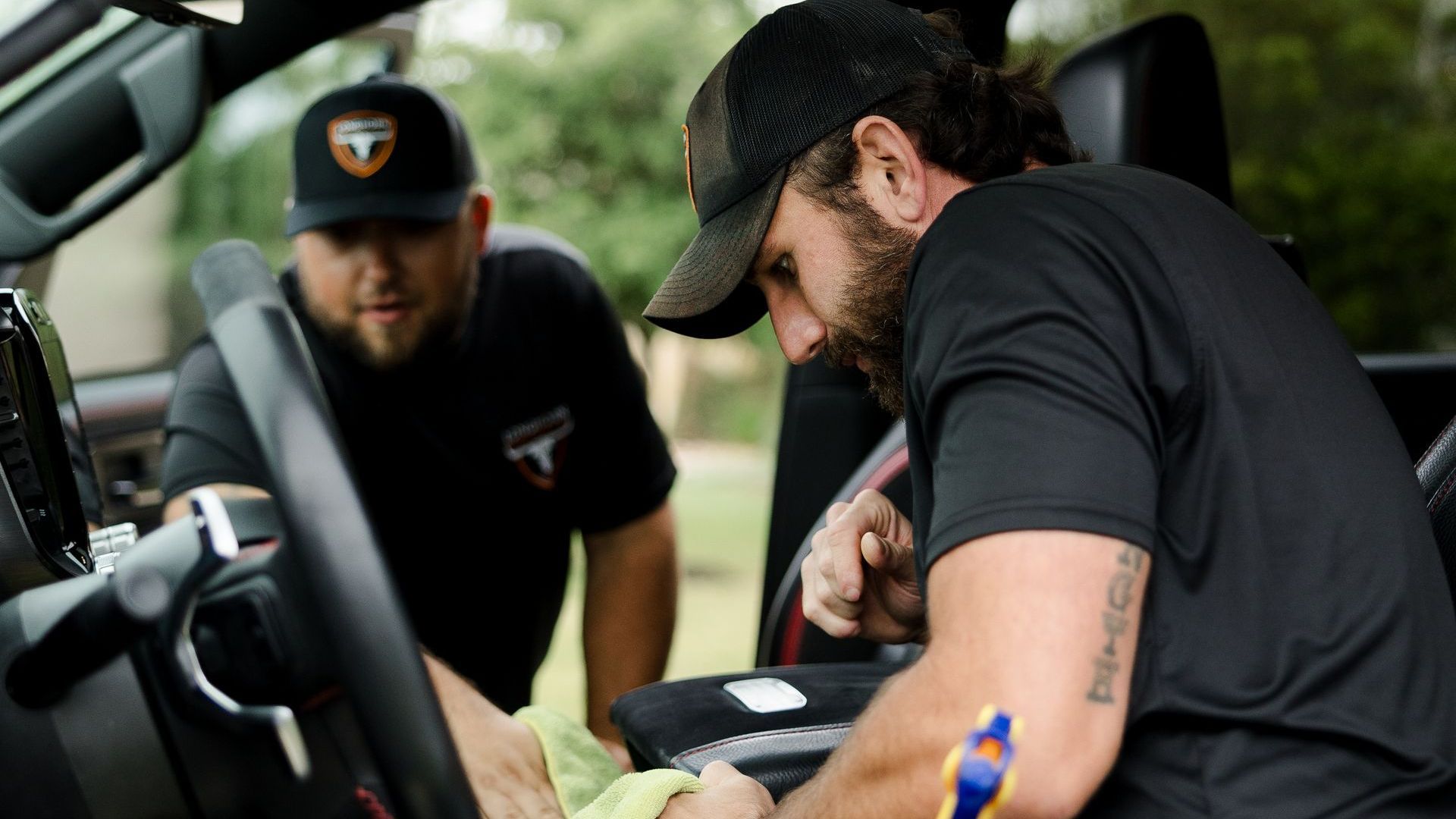 Protect your fleet with mobile detailing in Austin TX Woman on the phone and computer in car - protect your fleet investment with mobile detailing in Driftwood TX