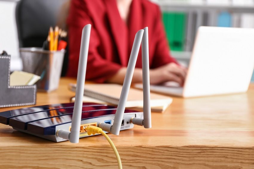 A Woman is Sitting at a Desk with a Laptop and a Router — Ardent Office Equipment in Charters Towers, QLD