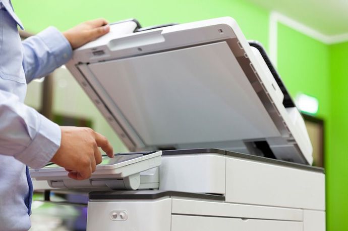 A Man is Using a Copier in an Office — Ardent Office Equipment in Hermit Park, QLD