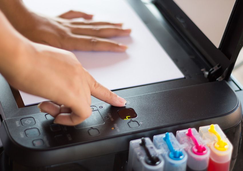 A Person is Pressing a Button on a Printer — Ardent Office Equipment in Ayr, QLD