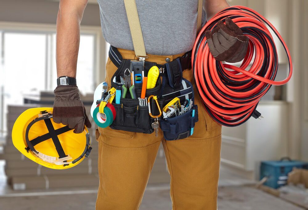 Electrician With Construction Tools And Cable — Premium Electrical Solutions in Bundaberg, QLD