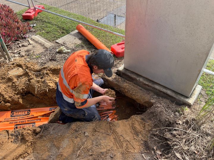 Expert Electrician Trying To Fix Switchboard — Premium Electrical Solutions in Bundaberg, QLD