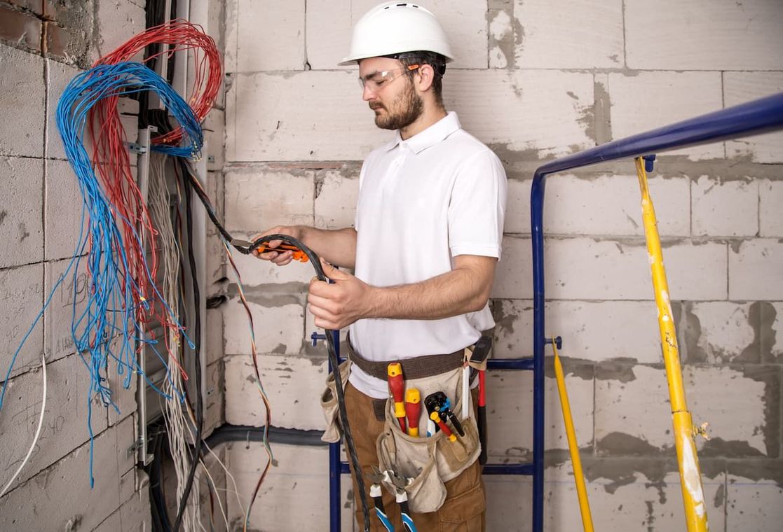 Electrician Working Near The Board With Wires. Installation And Connection Of Electrics — Premium Electrical Solutions in Bundaberg, QLD