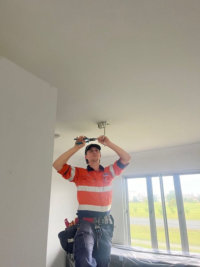 Electrician Builder At Work, Examines The Cable Connection In The Electrical Line — Premium Electrical Solutions in Bundaberg, QLD