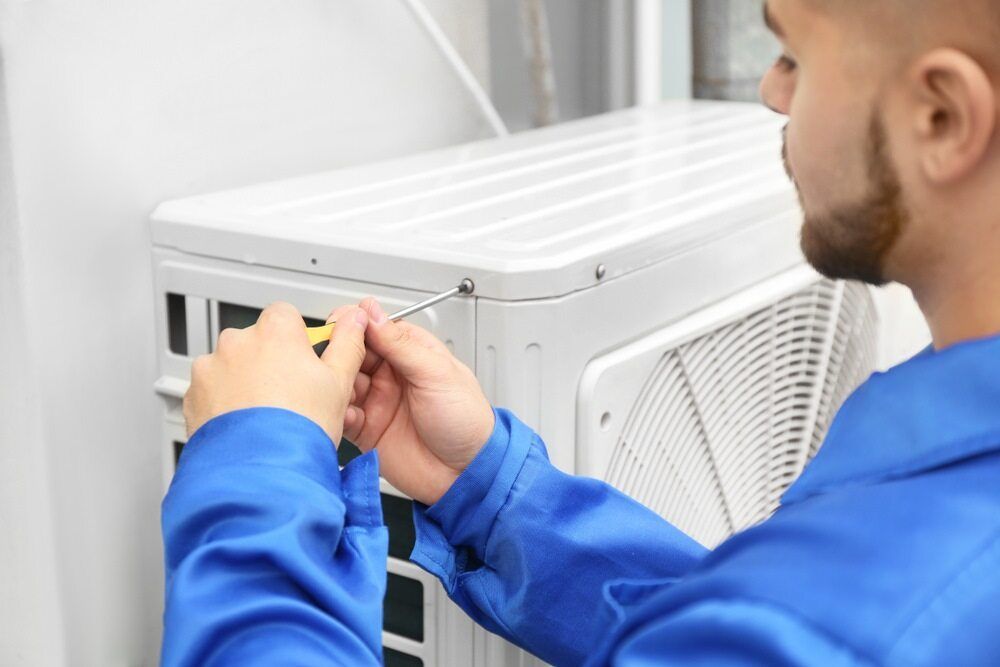 Skilled Electrician Repairing an Air Conditioner — Premium Electrical Solutions in Bundaberg, QLD