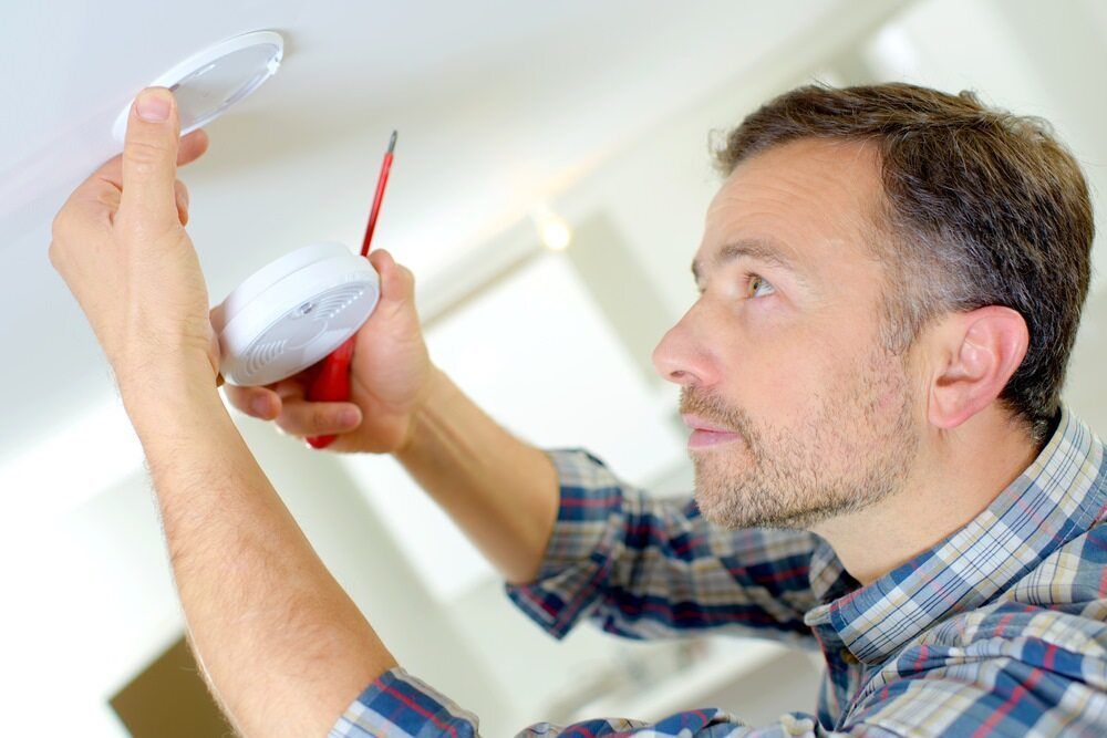 Electrician Fixing The Smoke Alarm — Premium Electrical Solutions in Bundaberg, QLD