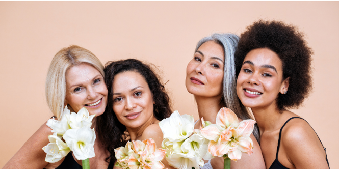A group of women are posing for a picture while holding flowers.