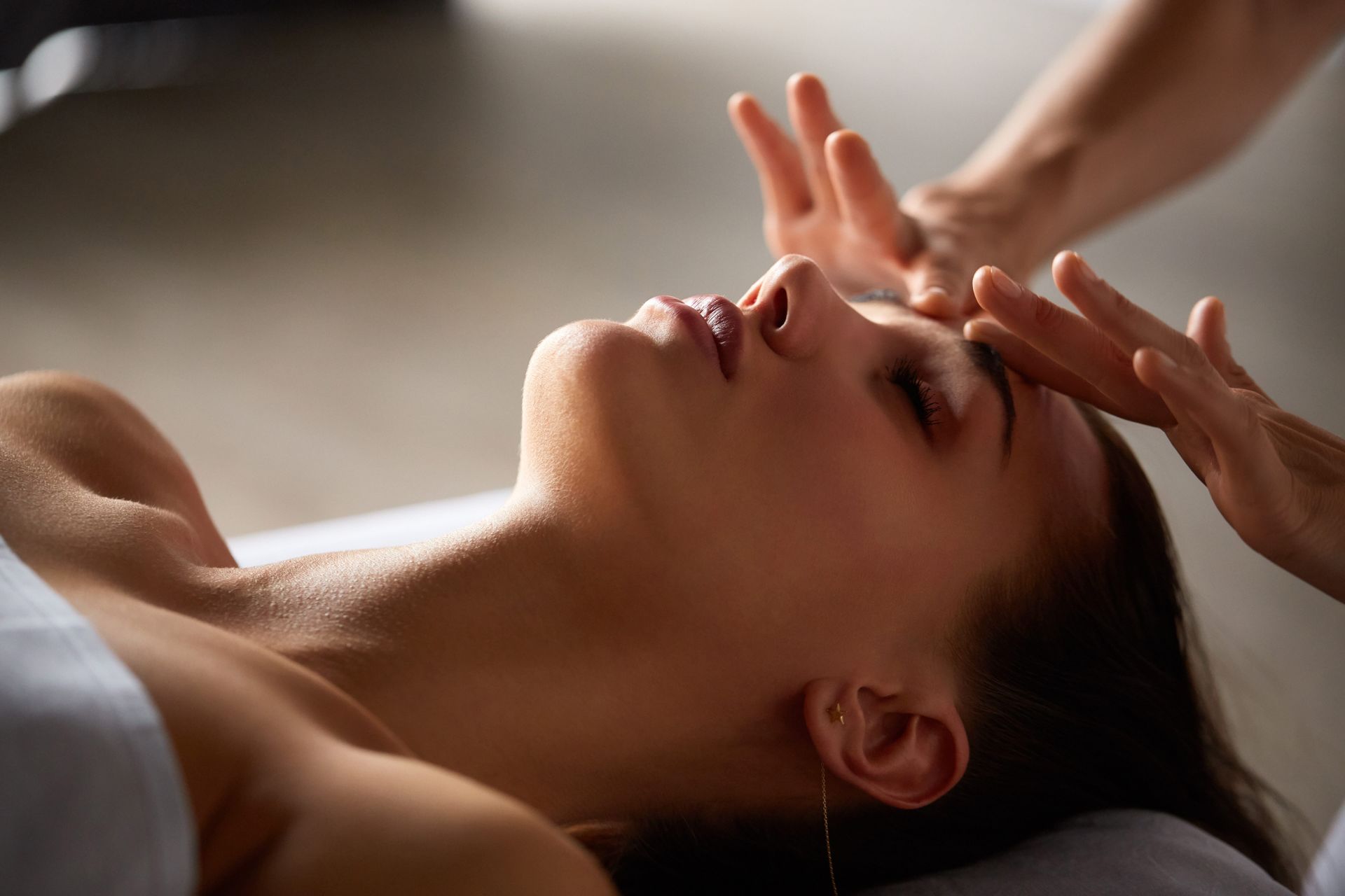 A woman is getting a facial massage at a spa.