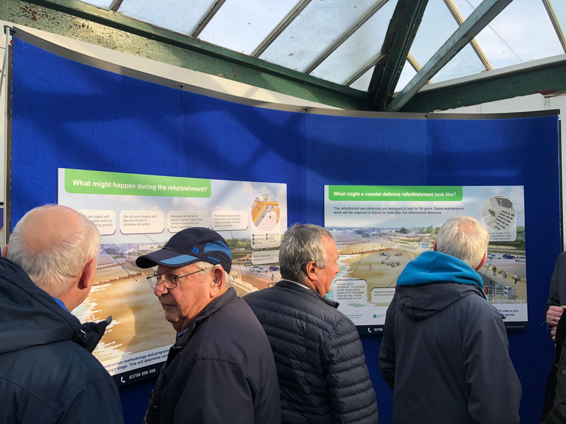 People looking at images created by Mark Bailey for the Sandown and Yaverland improved sea defence proposals