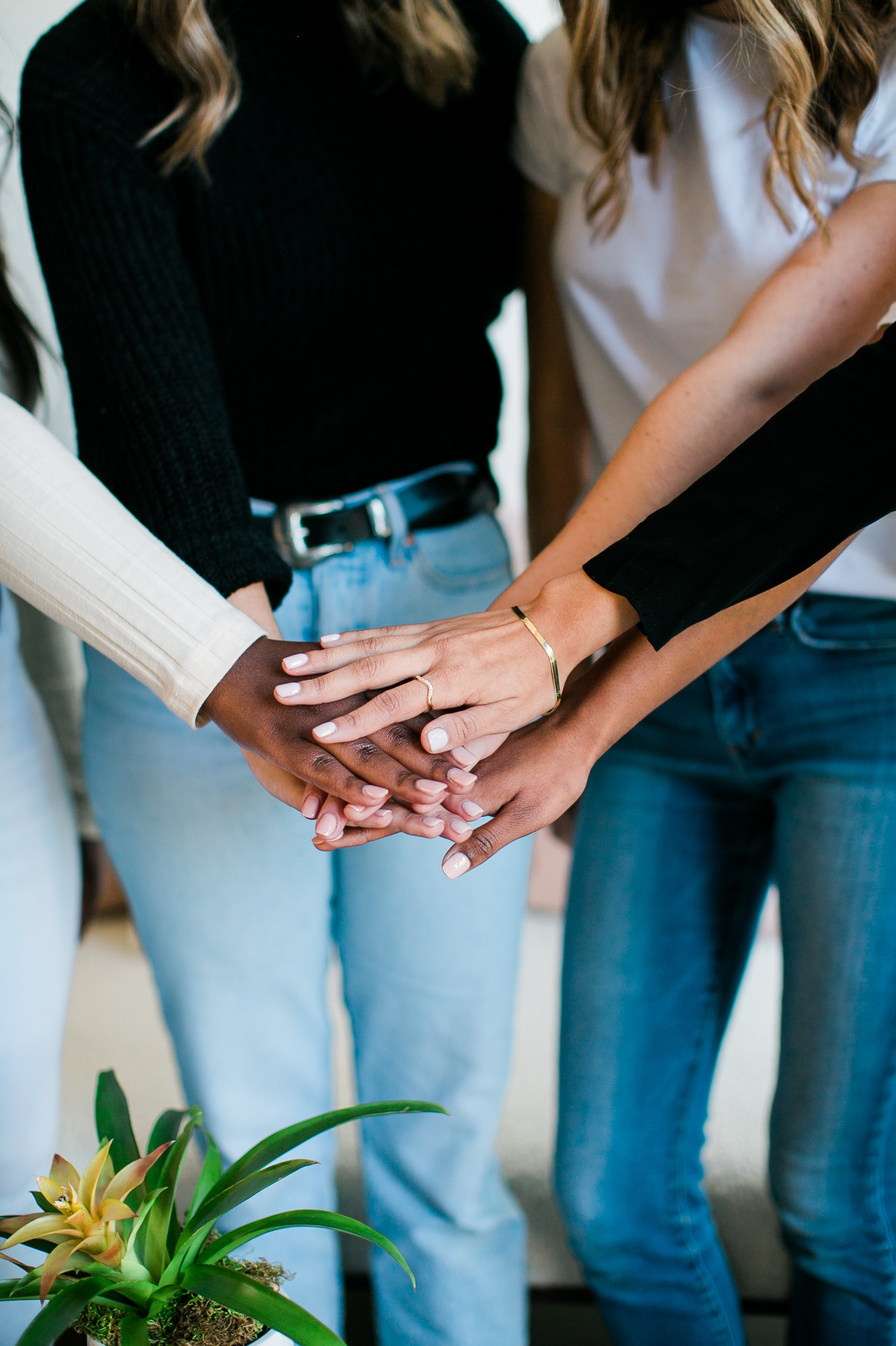 A group of women are putting their hands together.