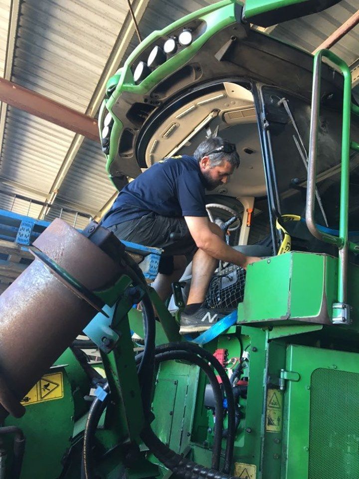 Man Working on Green Machinery. Indoors — Mobile Windscreens FNQ in Innisfail, QLD