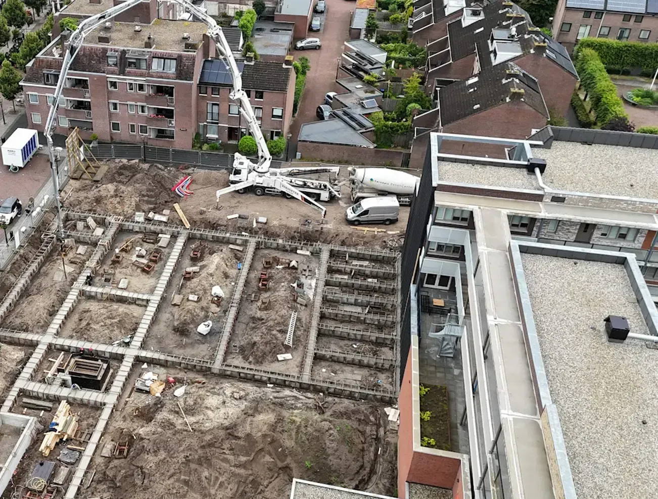 Een luchtfoto van een bouwplaats met een gebouw op de achtergrond