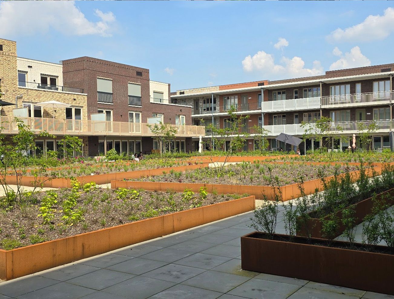 Een groot gebouw met veel planten ervoor