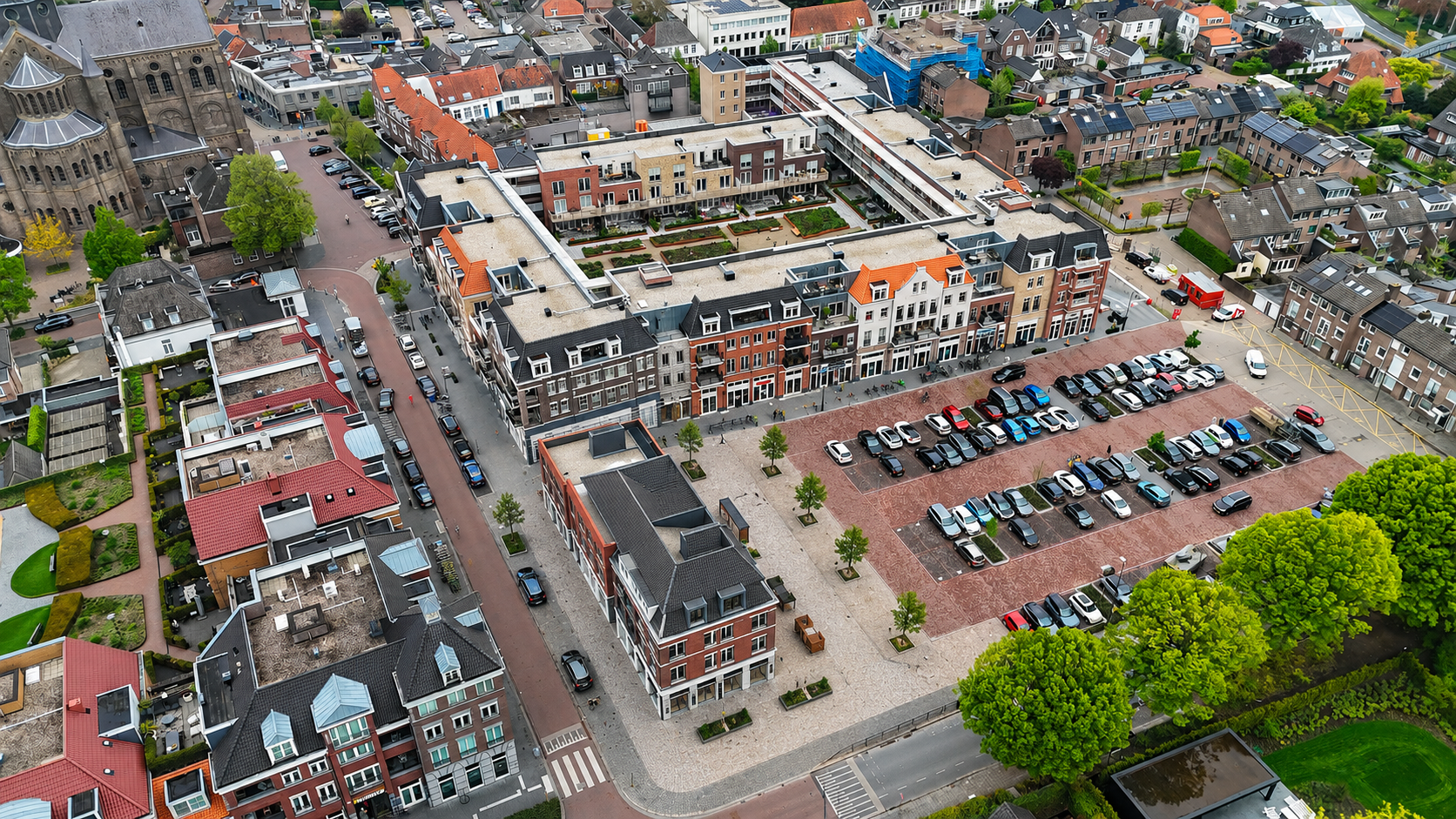 Een groot gebouw met veel planten ervoor