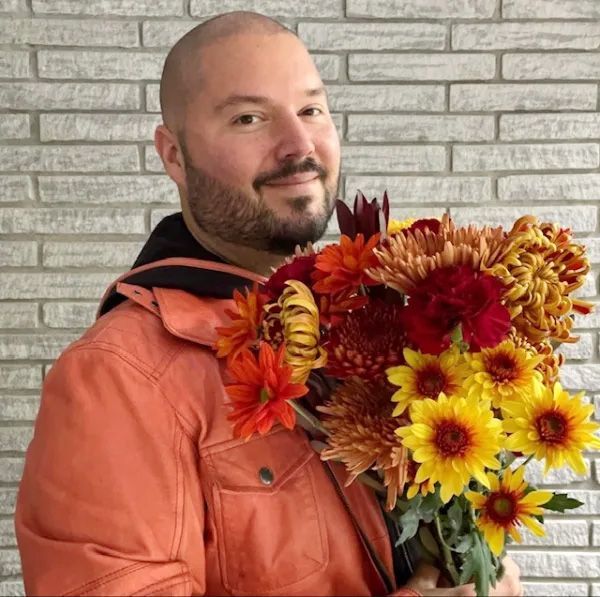 Full flower arrangement with a red/magenta colour palette on a festive table