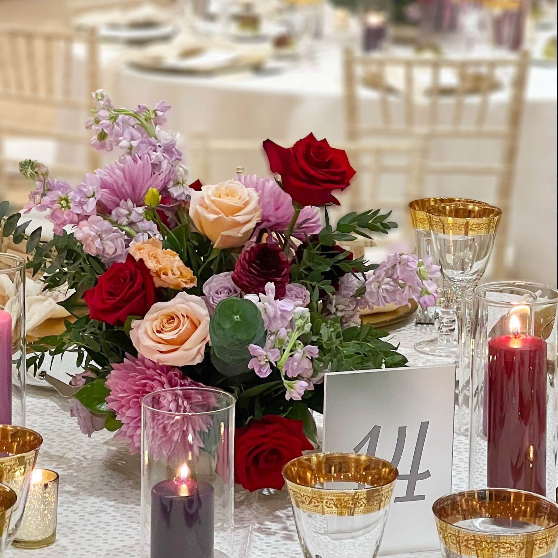 Full flower arrangement with a red/magenta colour palette on a festive table