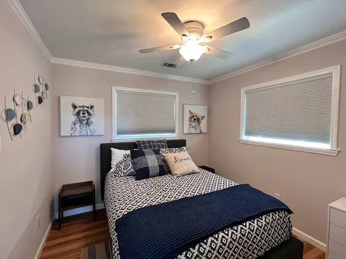 Bedroom with a queen bed, animal art, and light gray walls.