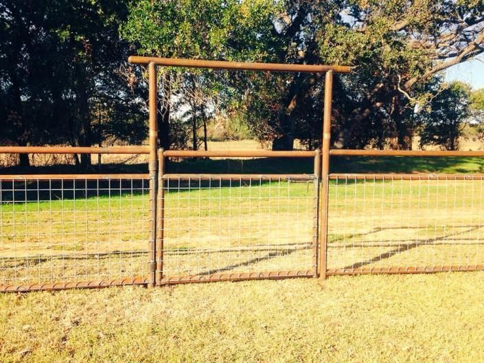 Pipe rail fence surrounding rural property.