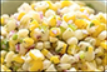 Corn salad with visible yellow corn, white and green pieces, with hints of red.