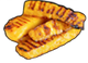 Grilled pineapple slices on a black surface; showing grill marks.