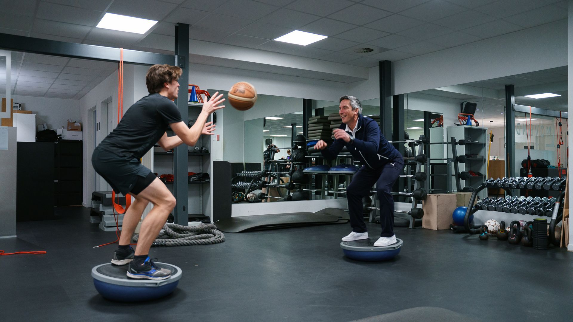 Een man en een vrouw doen oefeningen in een sportschool.