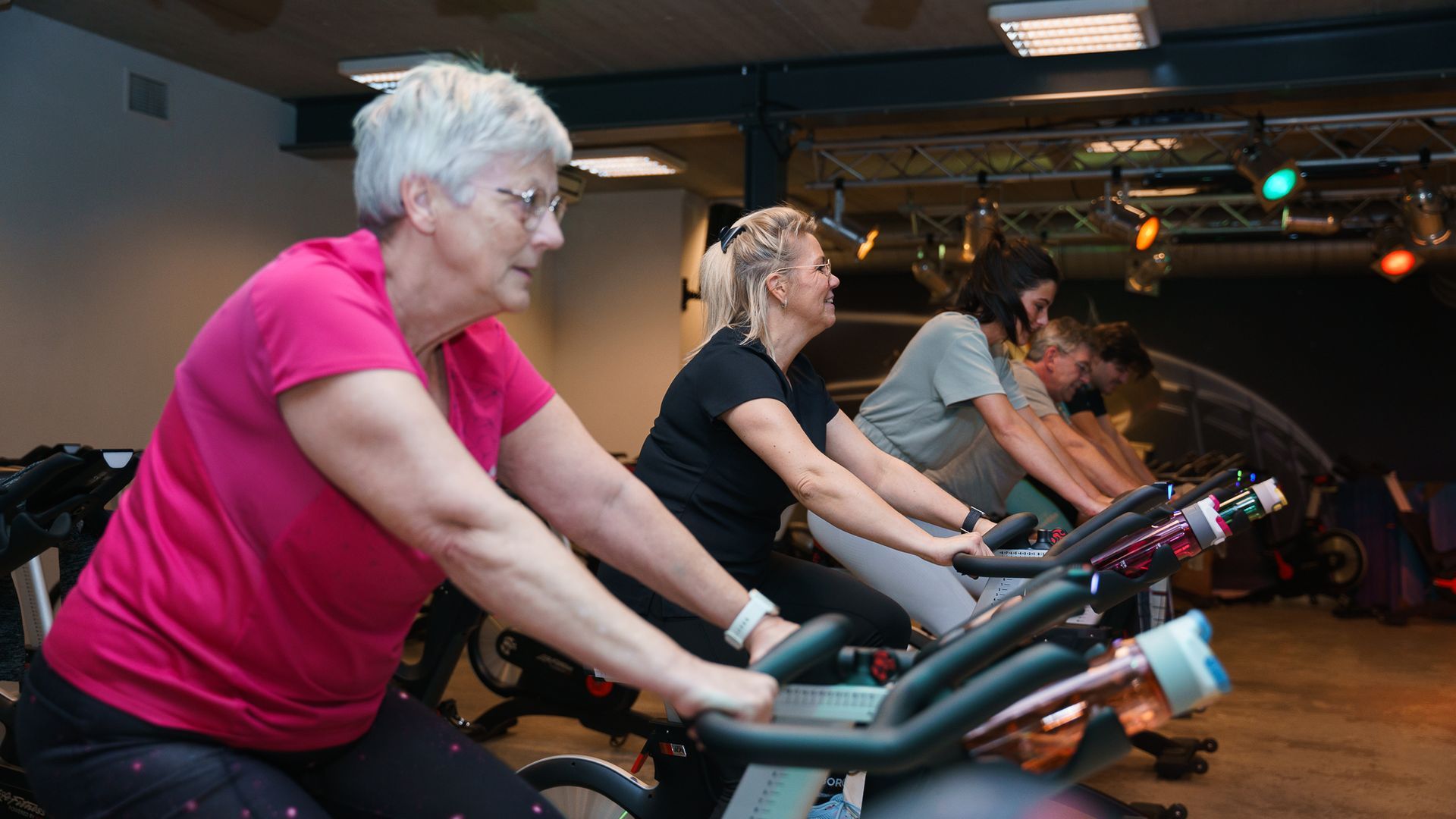 Een groep mensen rijdt op hometrainers in een sportschool.