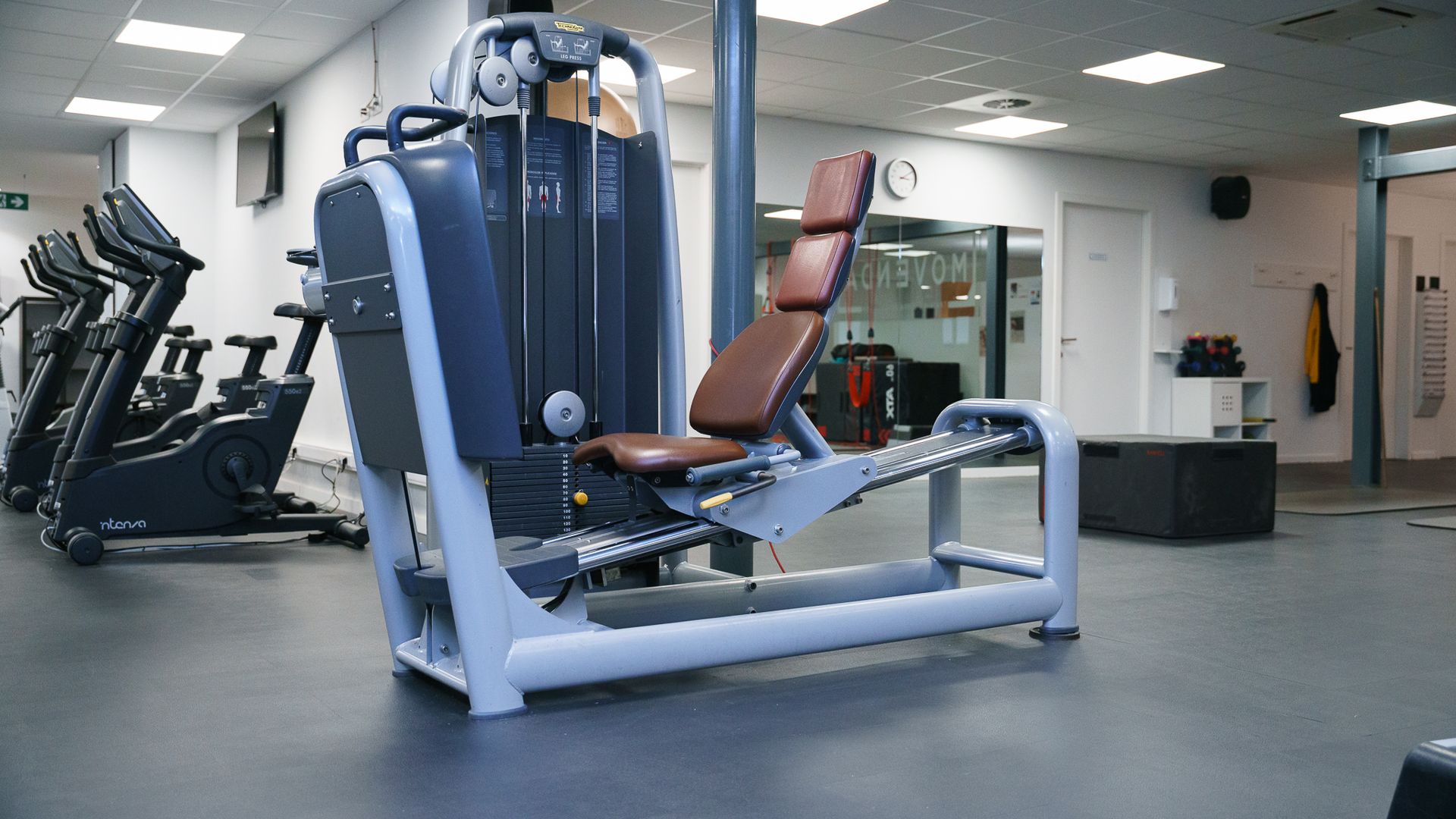 Twee mannen staan ​​naast elkaar in een sportschool.