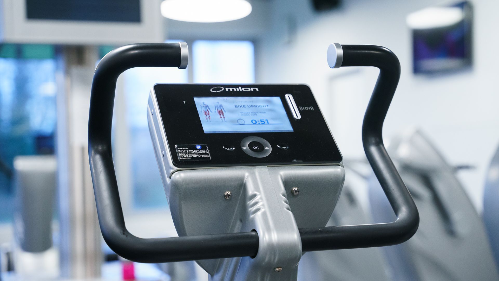 Een sportschool vol met veel fitnessapparatuur, waaronder een legpressmachine.