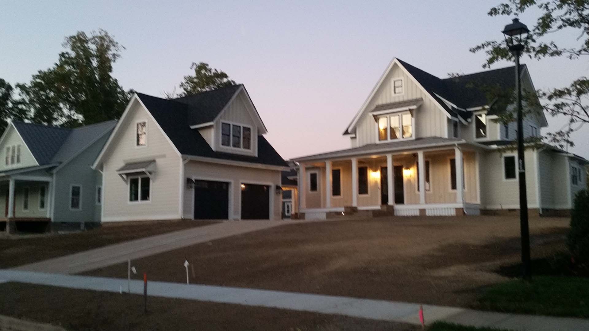 Two white houses with black roofs are next to each other