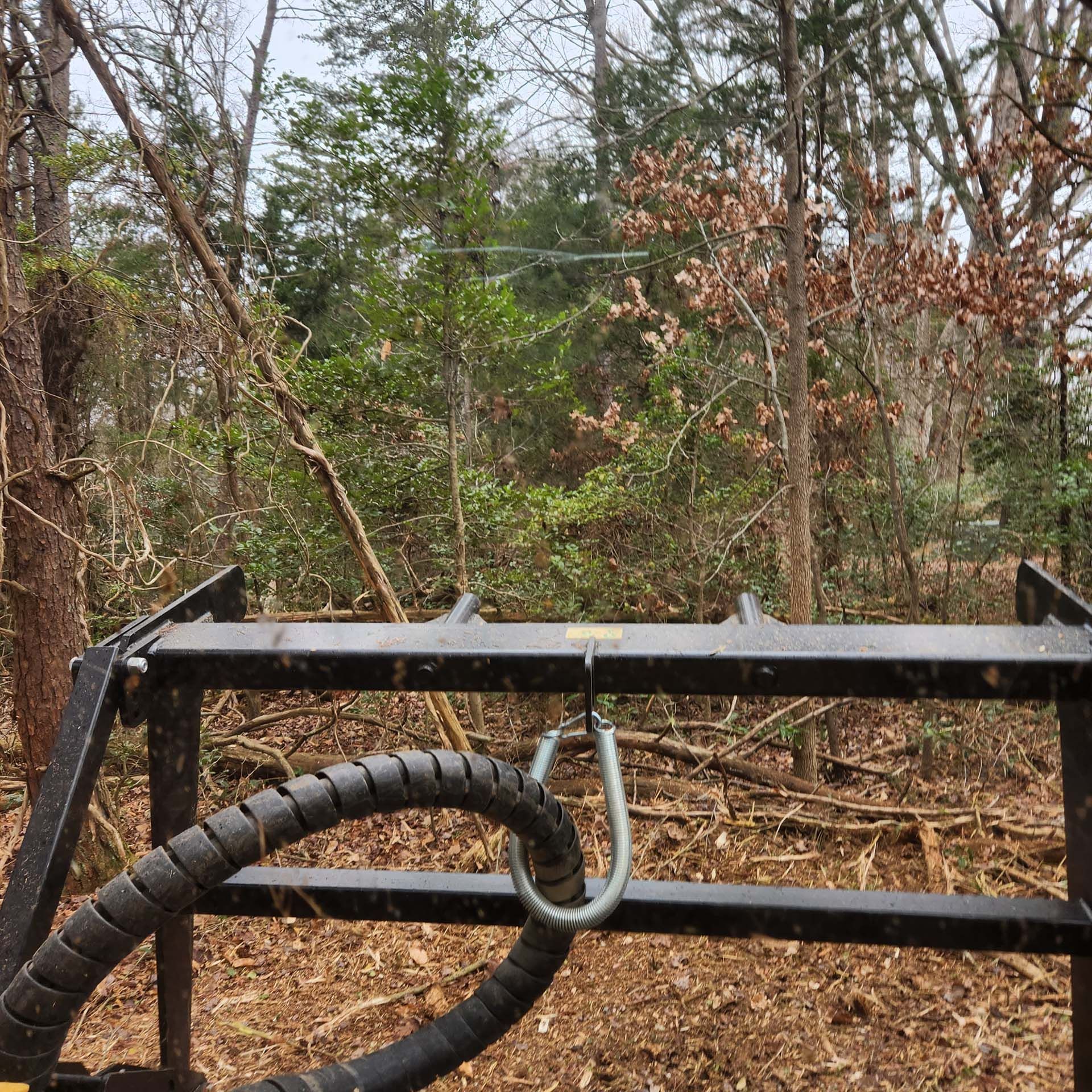 A hose is attached to a metal structure in the middle of a forest.
